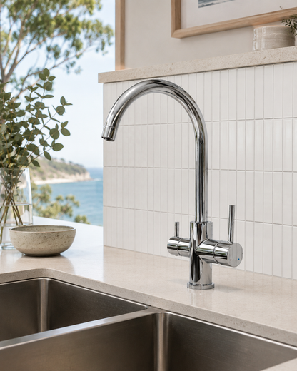 Modern kitchen sink with a chrome faucet overlooking a scenic view.