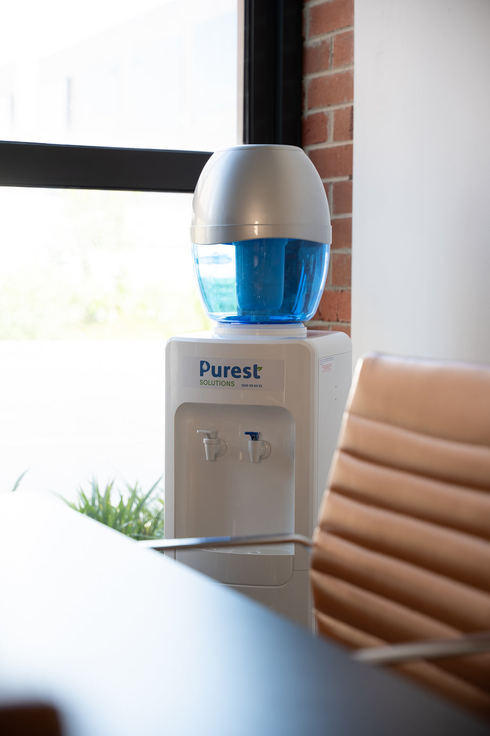 Purest refillable water cooler beside a meeting table in an office